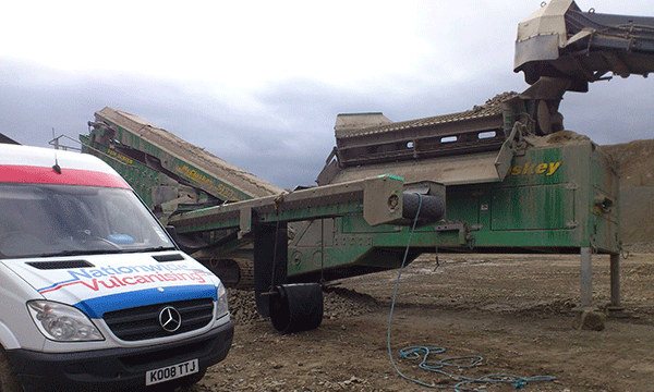 In this image, our van is shown next to a large conveyor system on a quarry site.